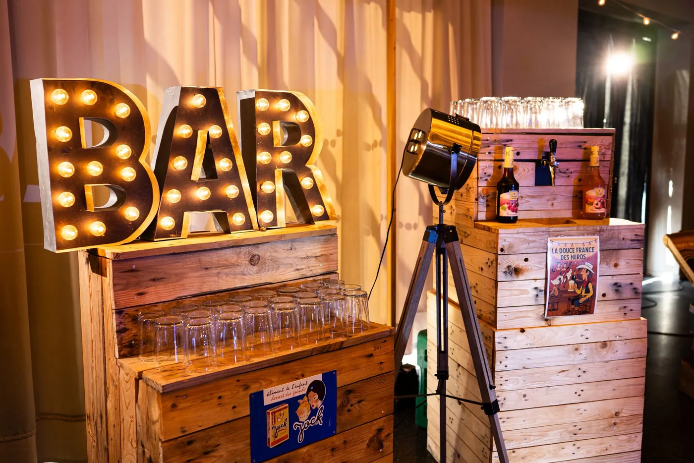 Comptoir en caisses de bois et lettres lumineuses BAR