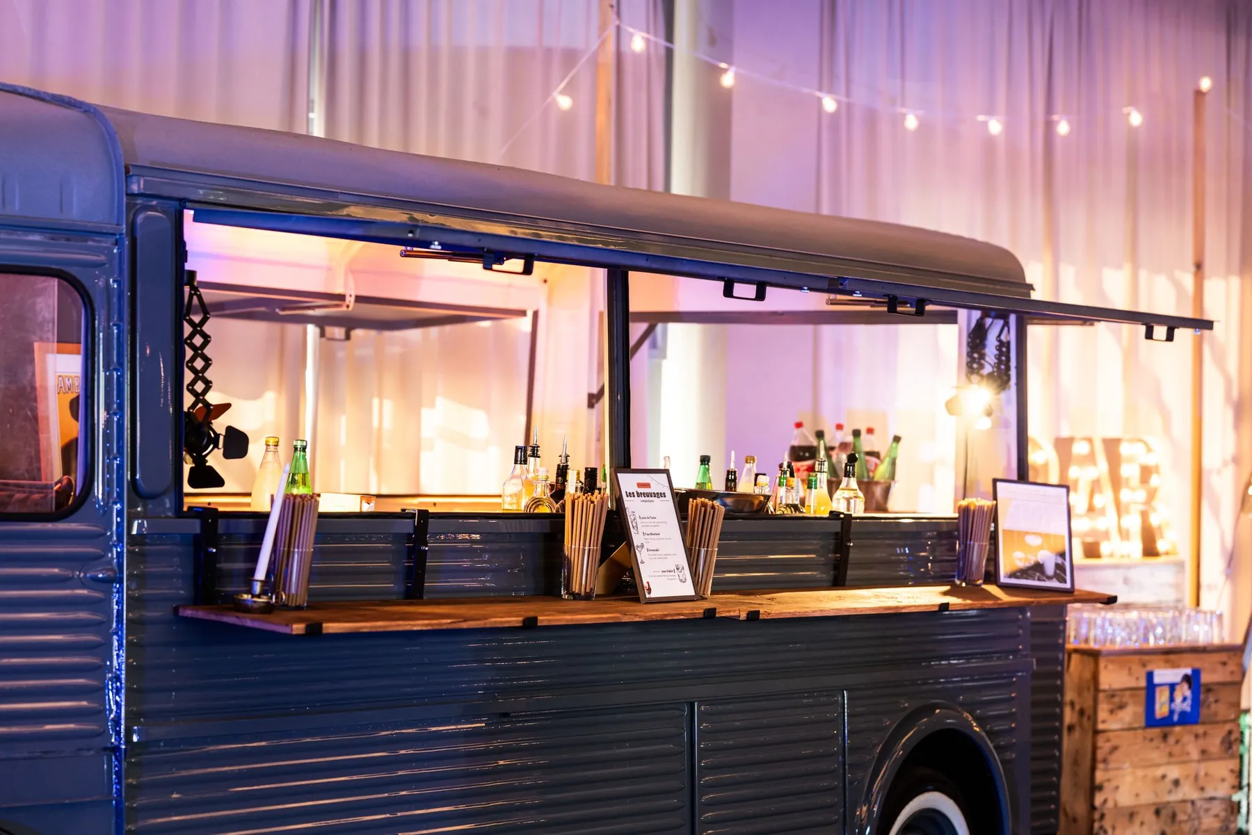Le flanc ouvert du camion bar, éclairé, bouteilles et comptoir